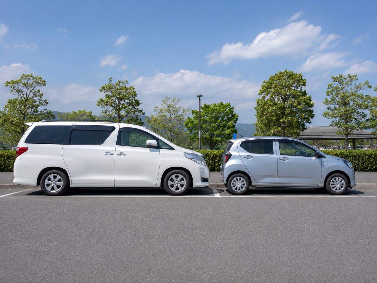 3ナンバー車と5ナンバー車の車体サイズを横から比較しているイメージ。無料写真素材で、コンパクトカーとミニバンまたはSUVを並べた自然な画像を使用する