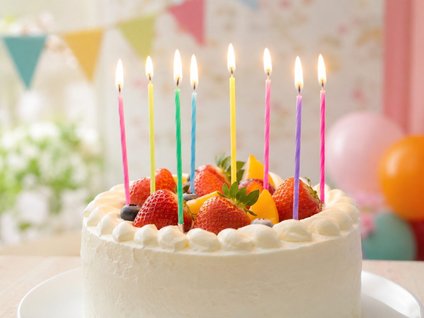 年齢に合わせて複数のろうそくを立てた誕生日ケーキの写真