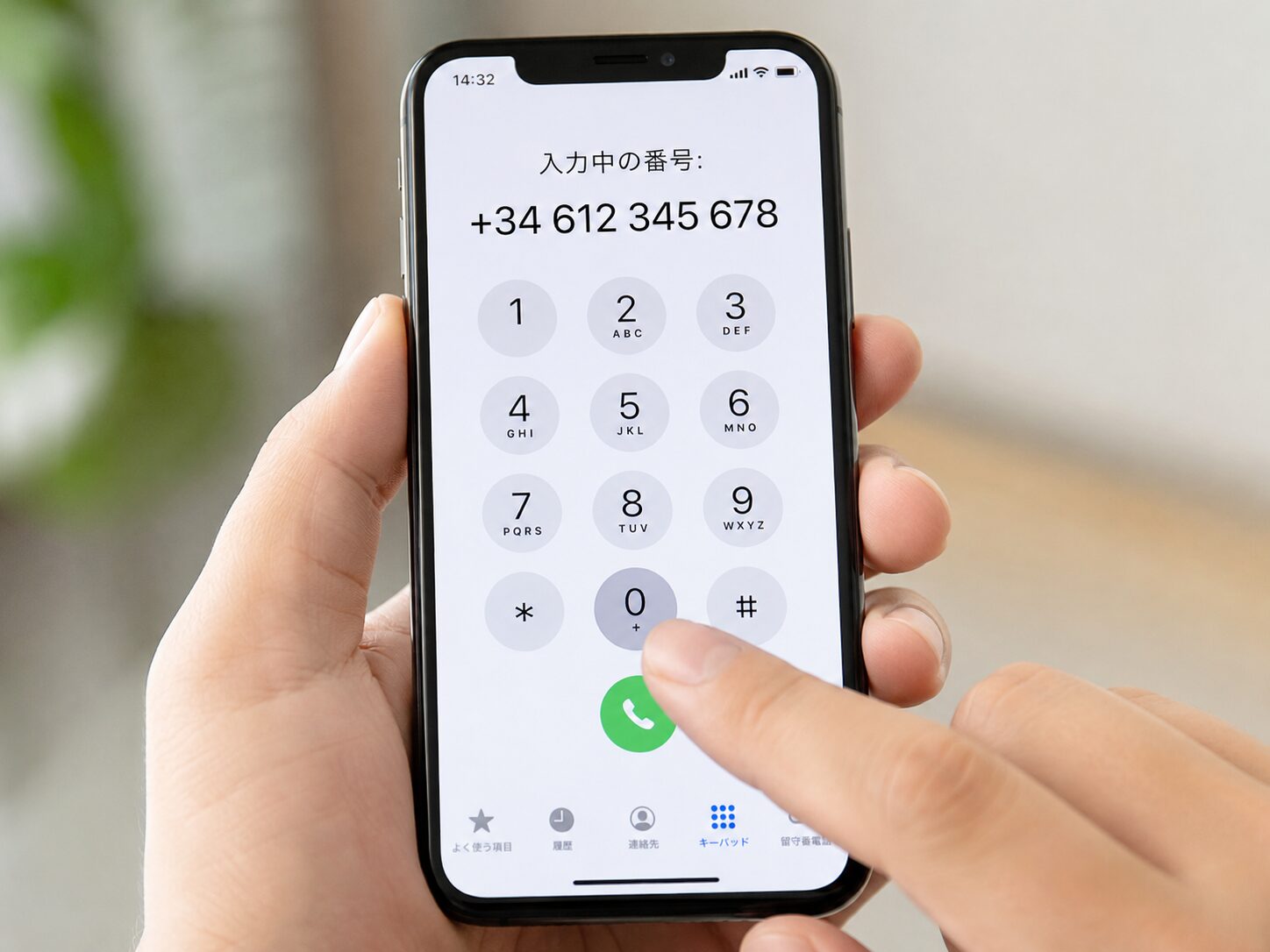スマートフォンのダイヤル画面で0を長押ししてプラスを表示し+34から始まるスペインの電話番号を入力している手元のイメージ