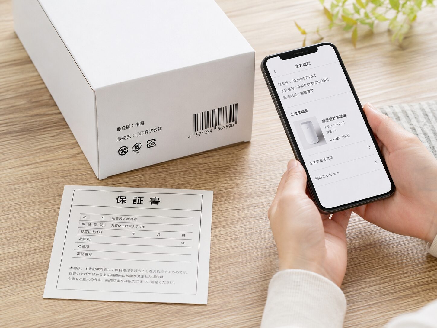 通販で届いた商品のバーコード、原産国表示、販売元、保証書を机の上で確認しているイメージ。無料写真素材で、商品箱、バーコード、原産国表示、保証書、スマートフォンが分かる画像を使用する