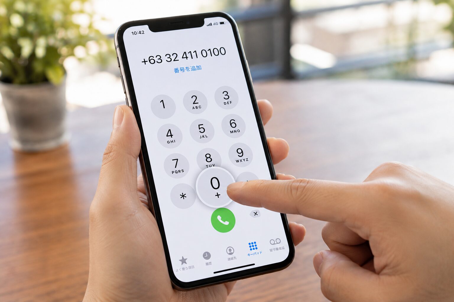スマートフォンの電話アプリで0を長押ししフィリピンの国番号+63とセブの固定電話番号を入力している手元の写真