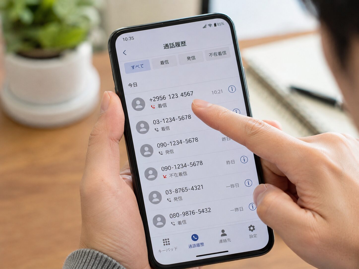 スマートフォンの着信履歴にプラス2956から始まる見知らぬ番号が表示され、番号全体を確認している写真