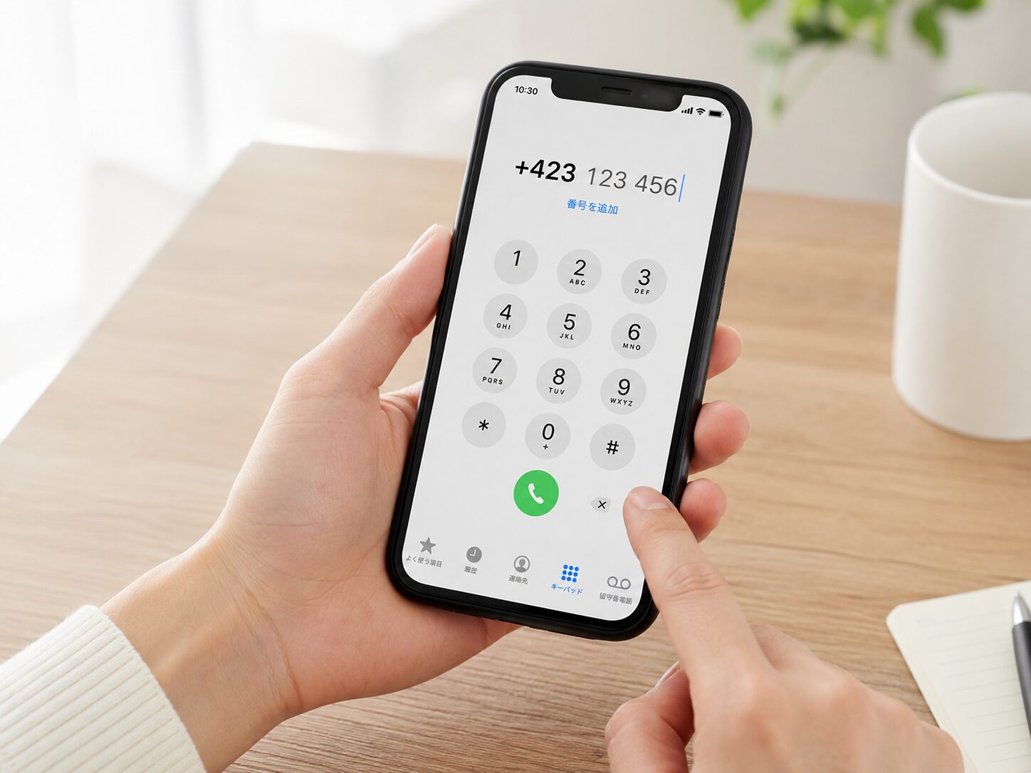 スマートフォンでリヒテンシュタインの国番号+423を入力しているイメージ