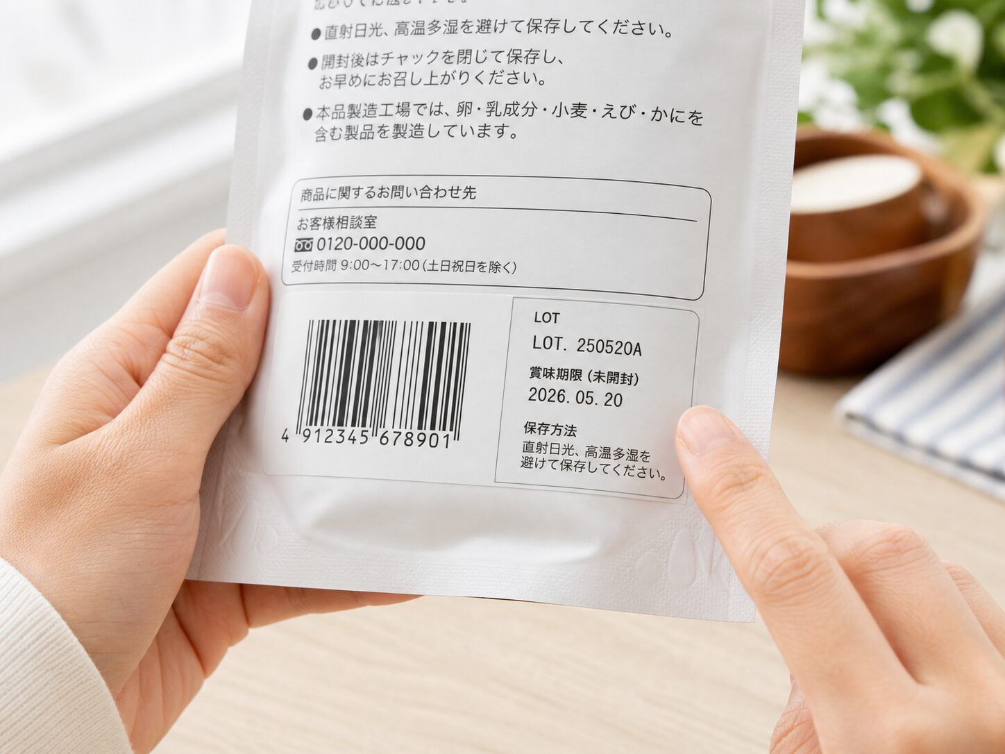 商品パッケージのバーコード周辺にあるロット番号や期限表示を確認しているイメージ