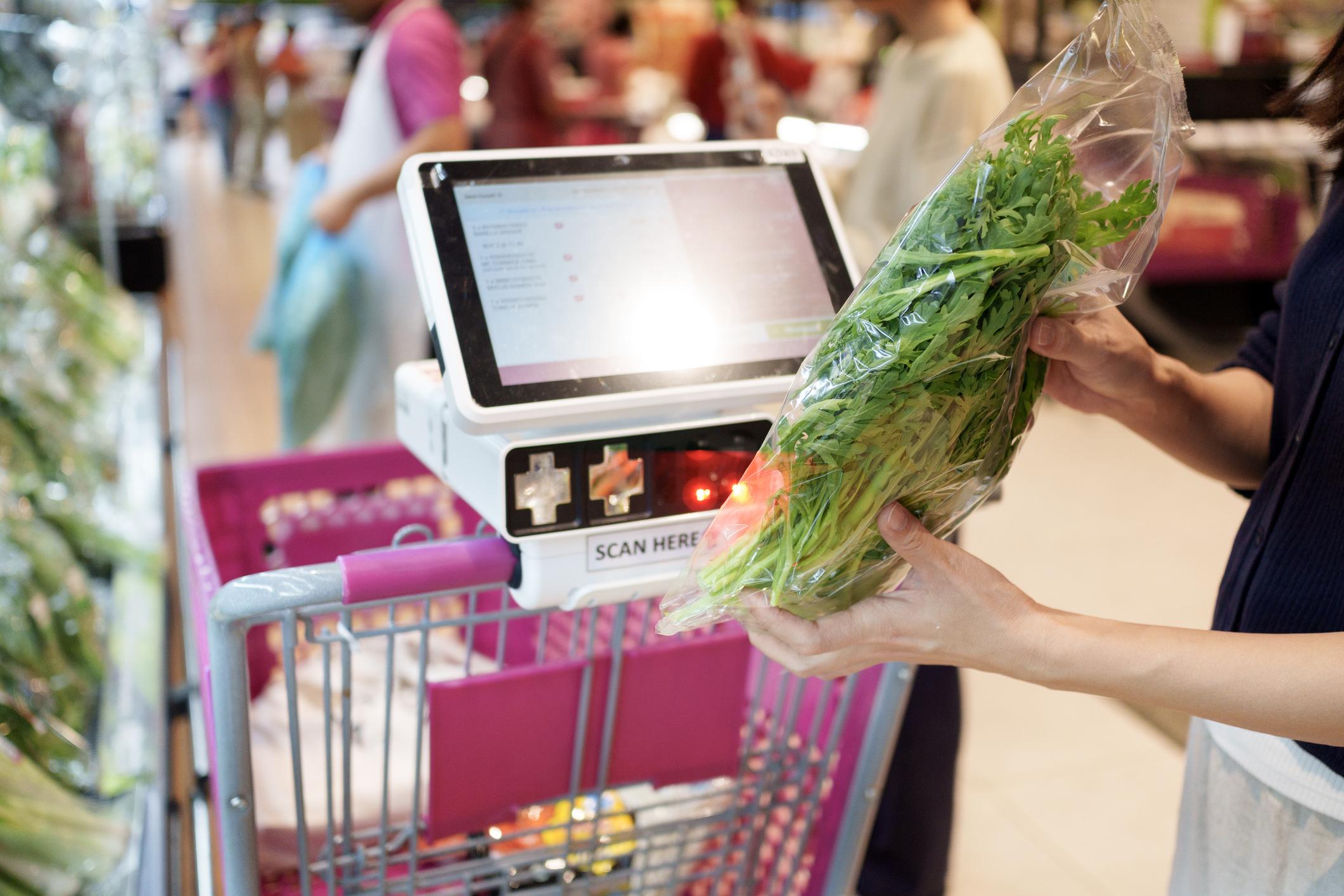 スーパーマーケットのレジでバーコードを読み取っている様子の写真（無料素材向け）